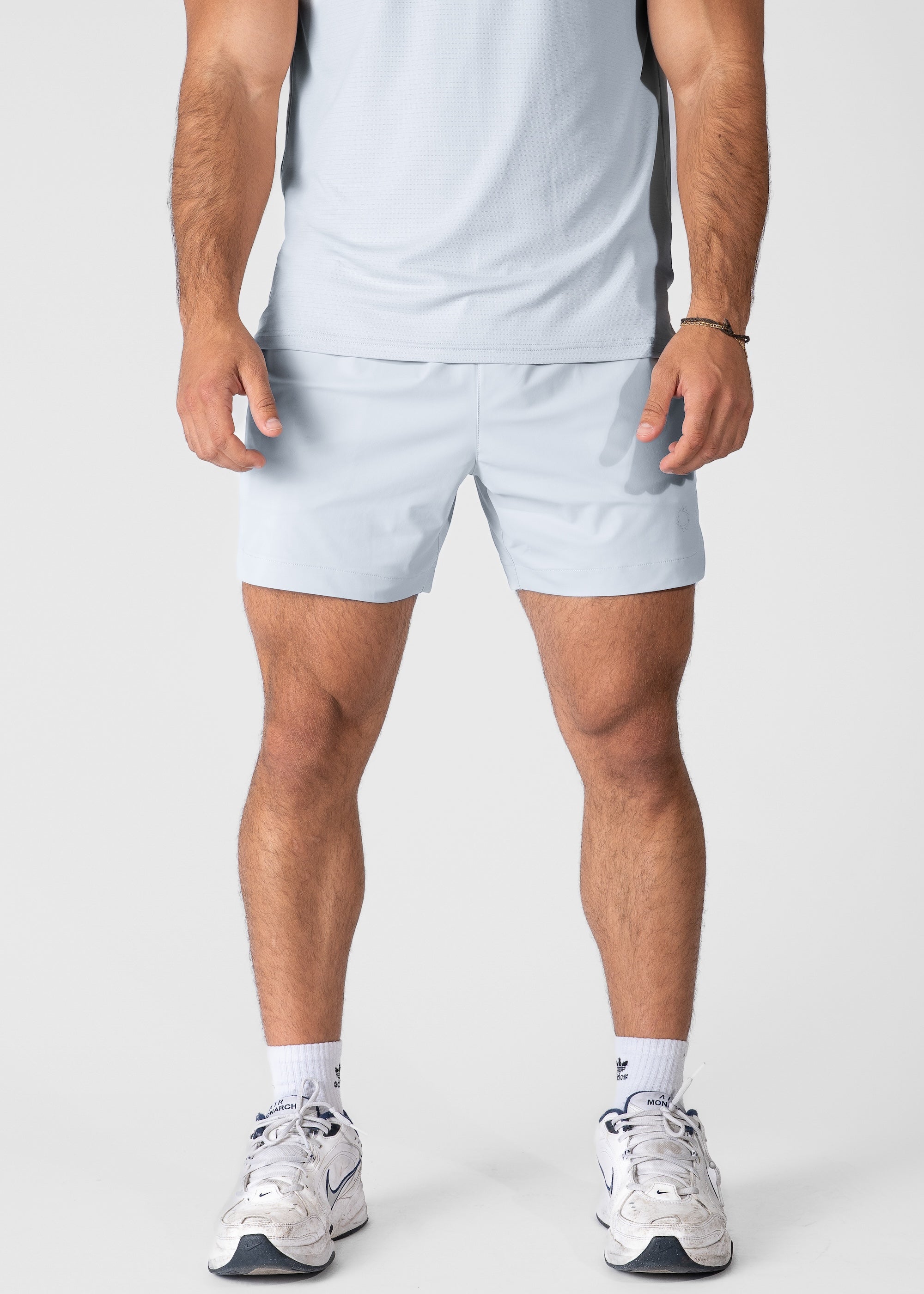 Man wearing light blue hybrid shorts on plain background. #color_light blue #model_A