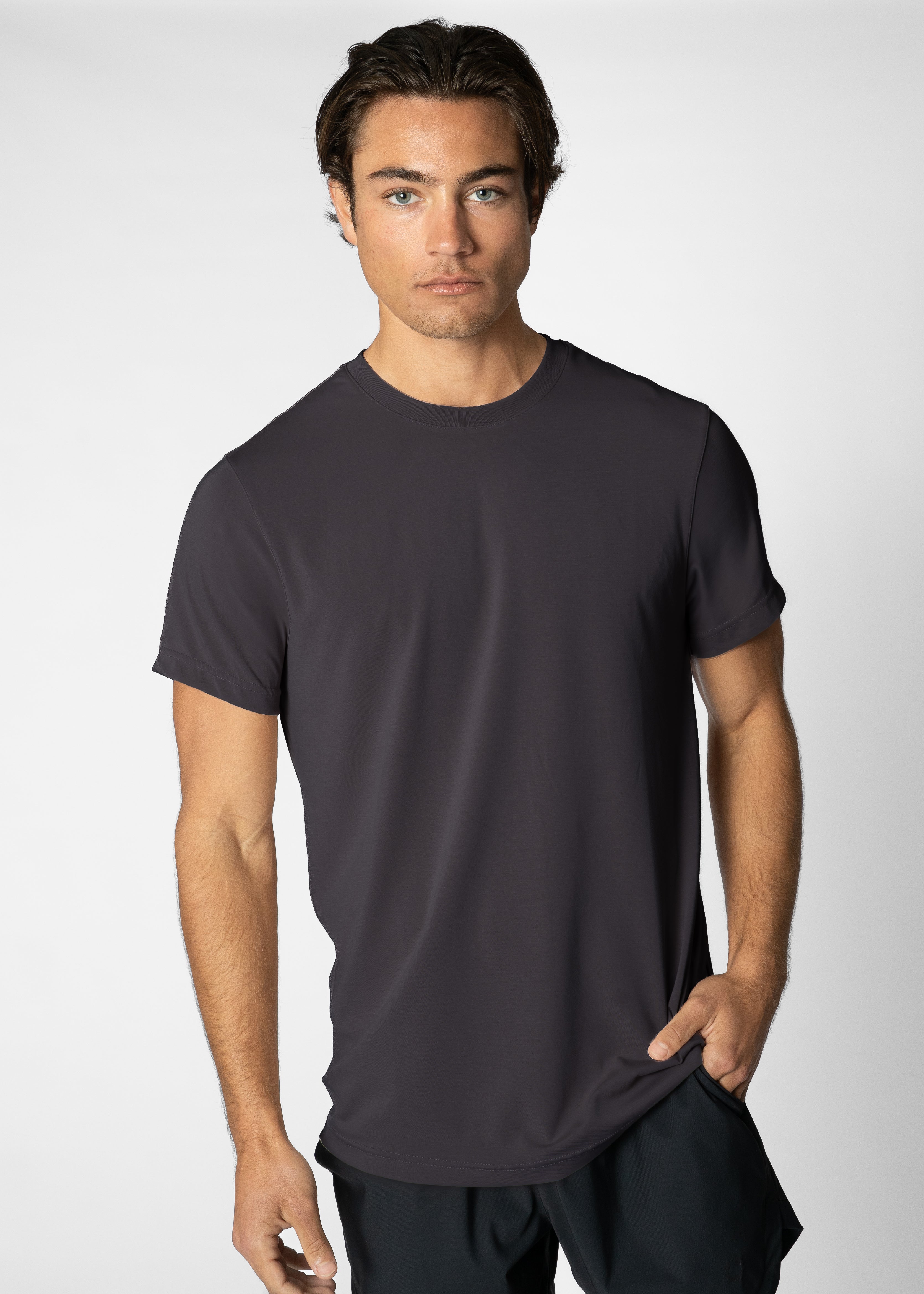 Man wearing a dark grey t-shirt against a plain background #color_charcoal grey #model_A