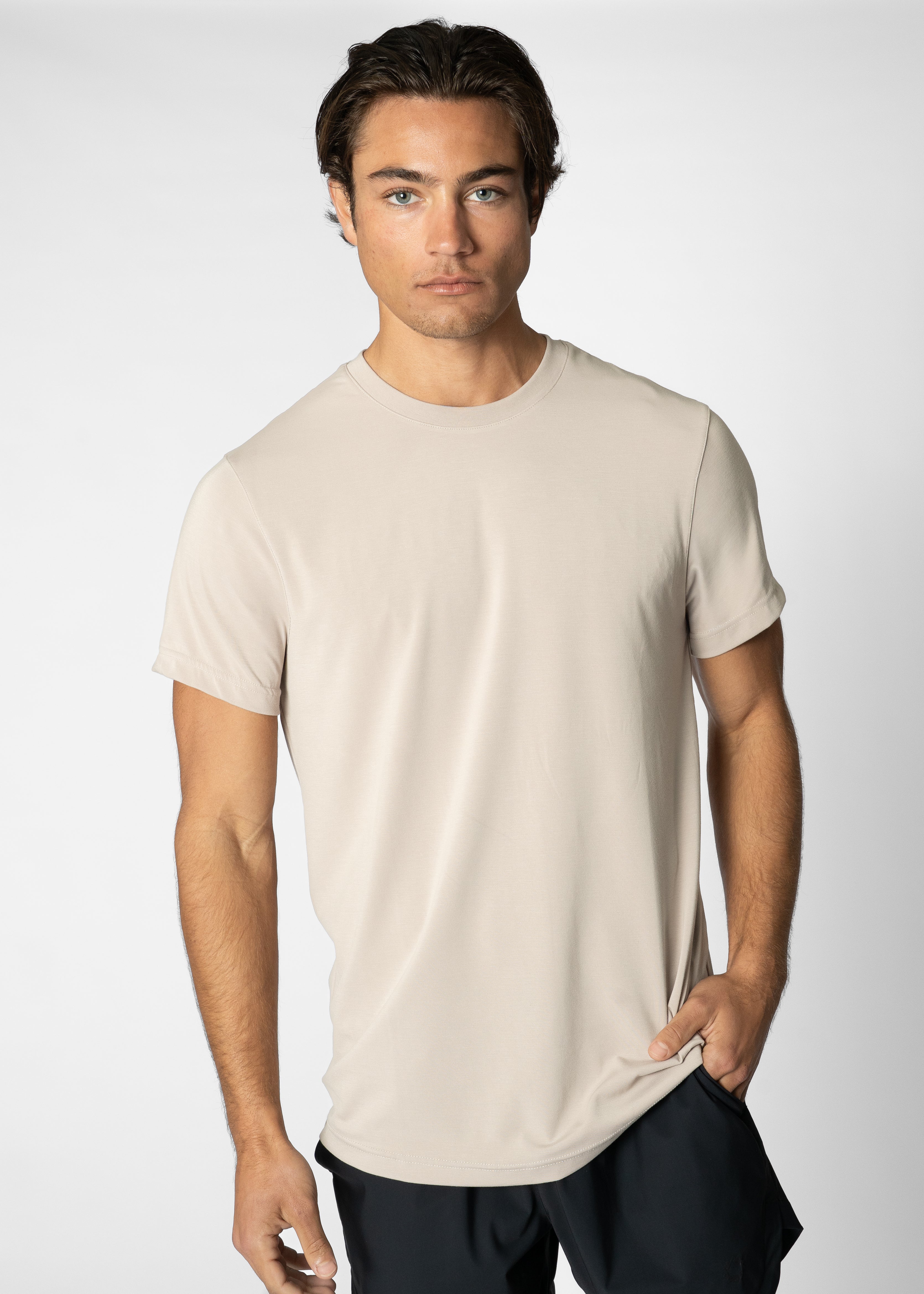 Man wearing a beige t-shirt against a plain background #color_sand #model_A