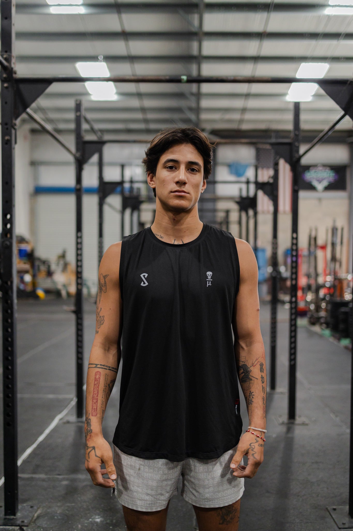 An athlete at the gym wearing the SquidHaus fitted tank top