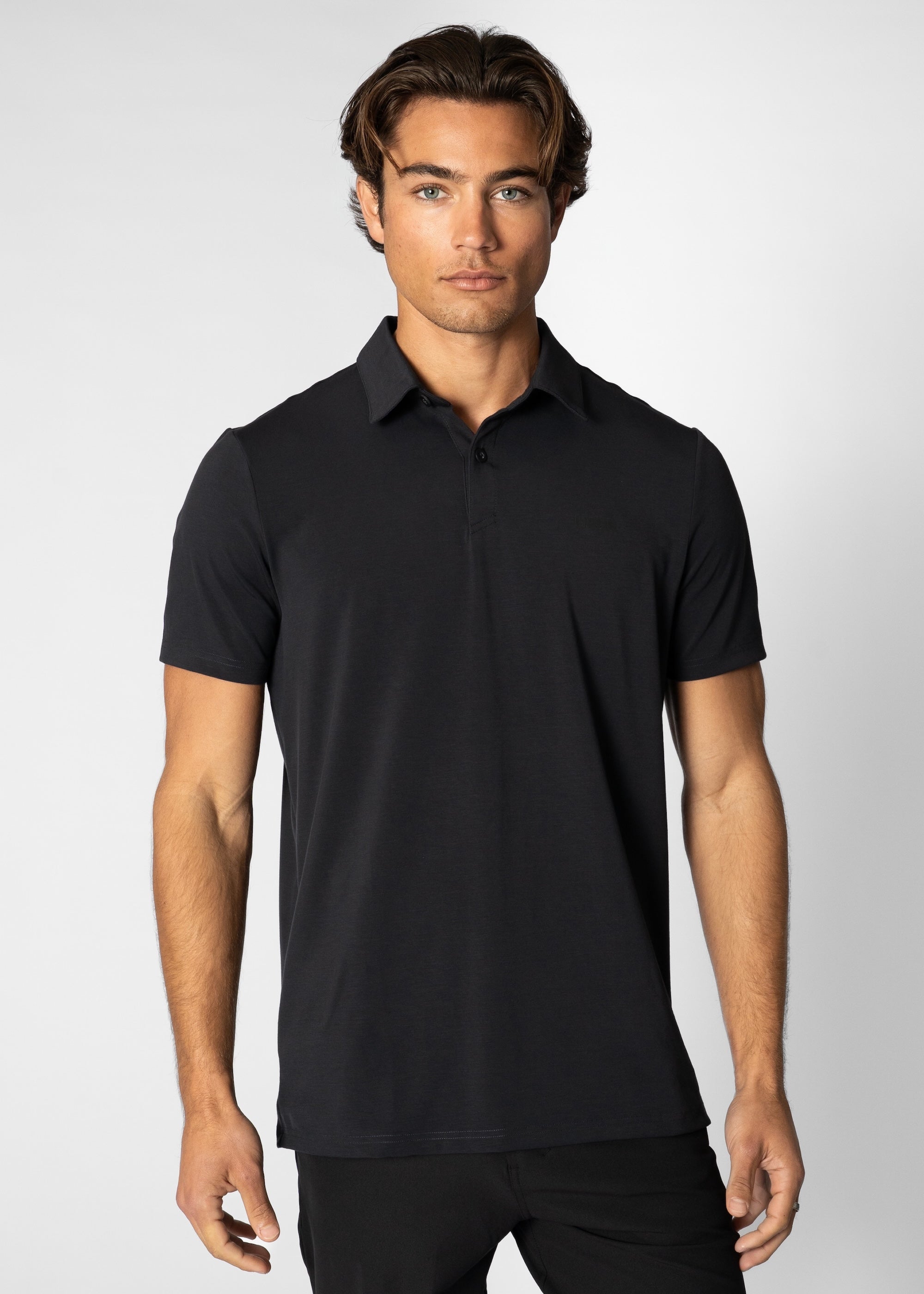 Man wearing a black polo shirt against a white background #color_black #model_A