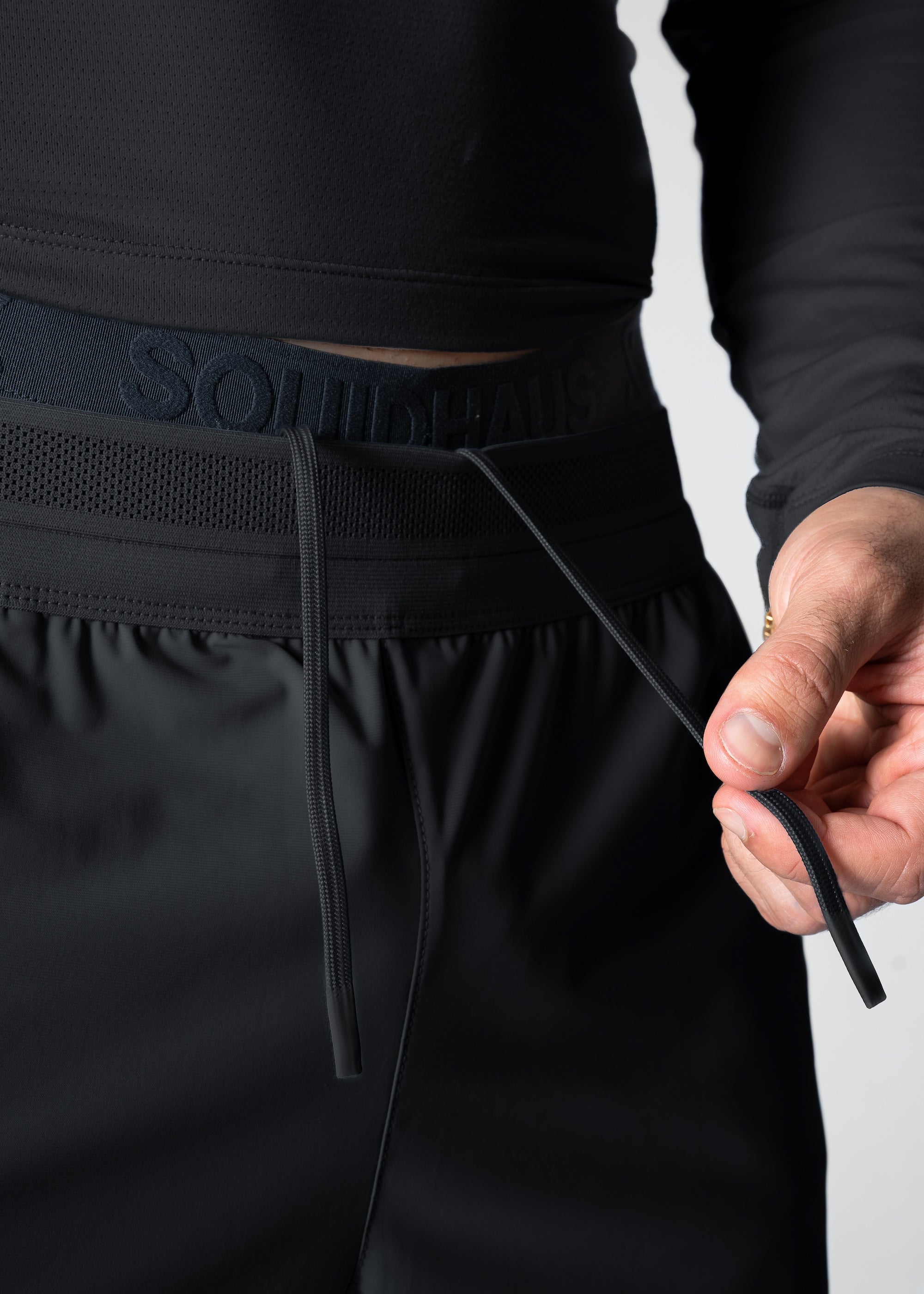 Close-up detail shot of waistband and internal drawstrings. #color_black