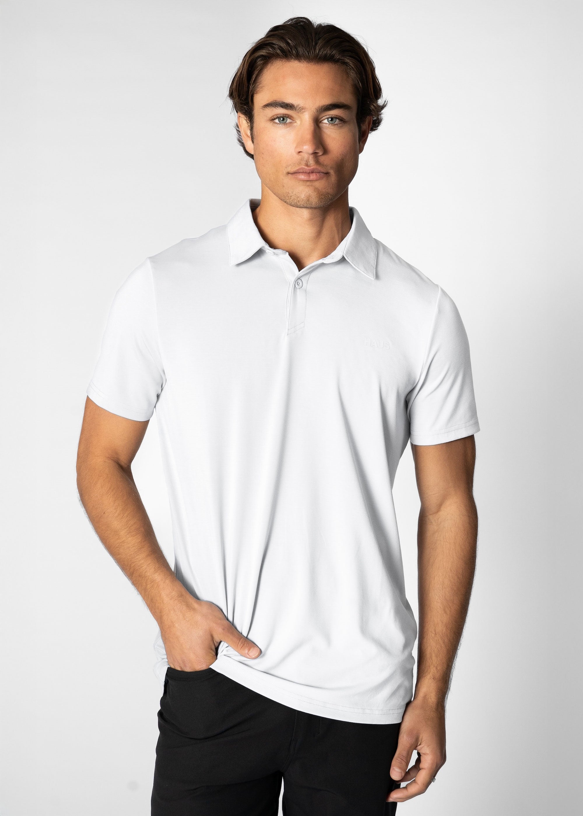Man wearing a white polo shirt against a plain background #color_white #model_A