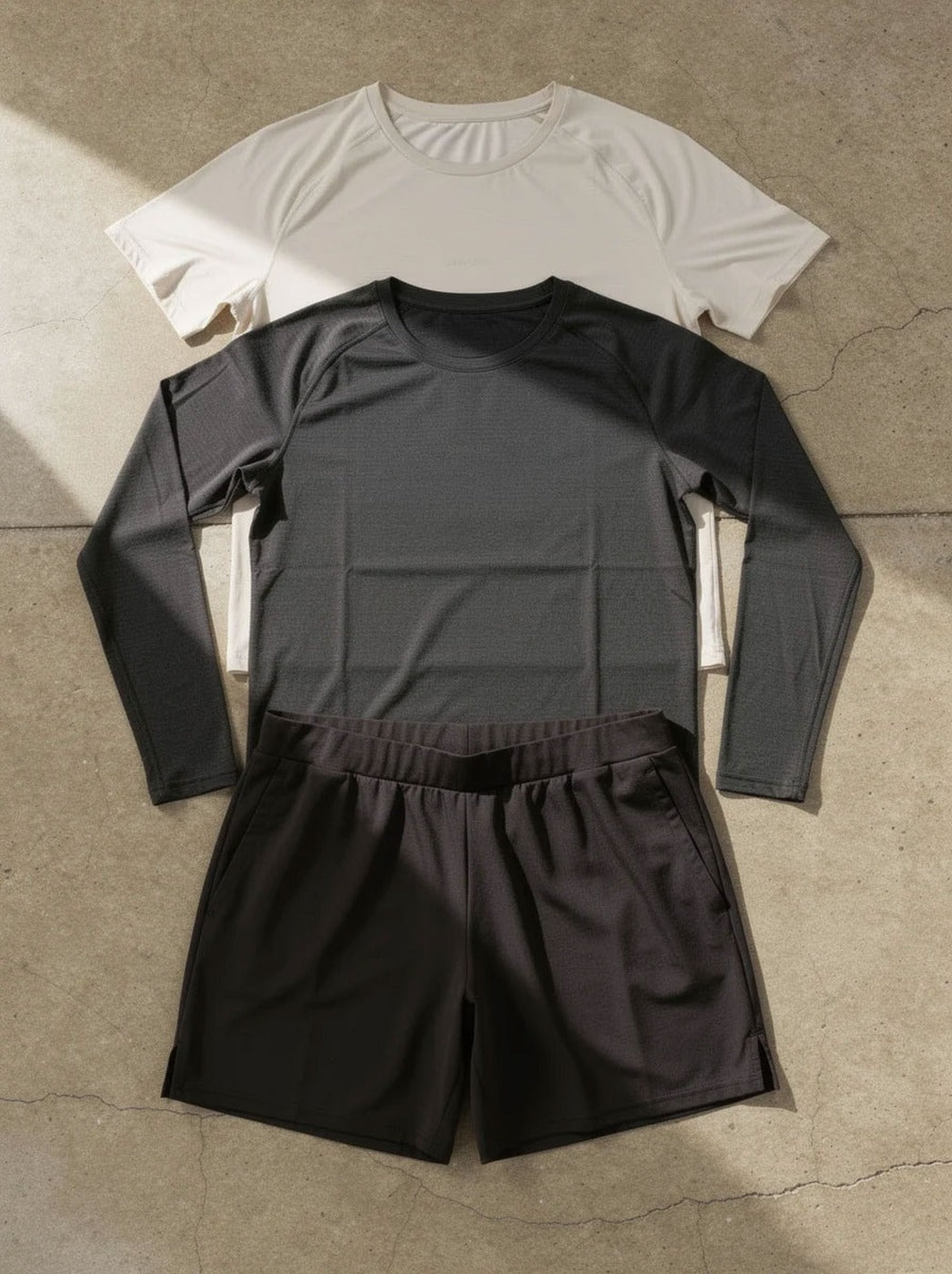 The Essentials Set flatlay — short sleeve tee, long sleeve tee and 5 inch short
